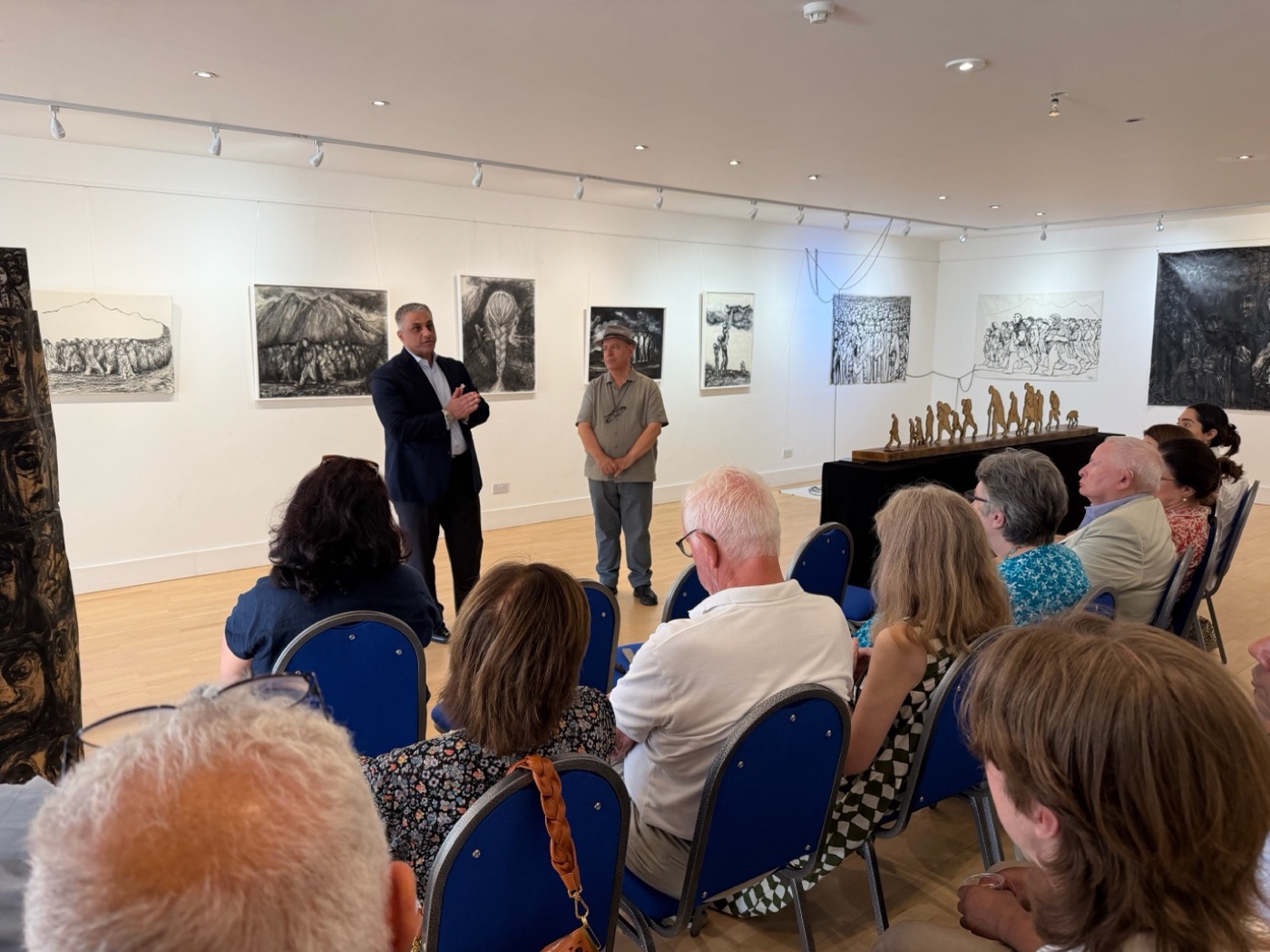 Speakers address a seated audience at a Kurdistan Society exhibition event